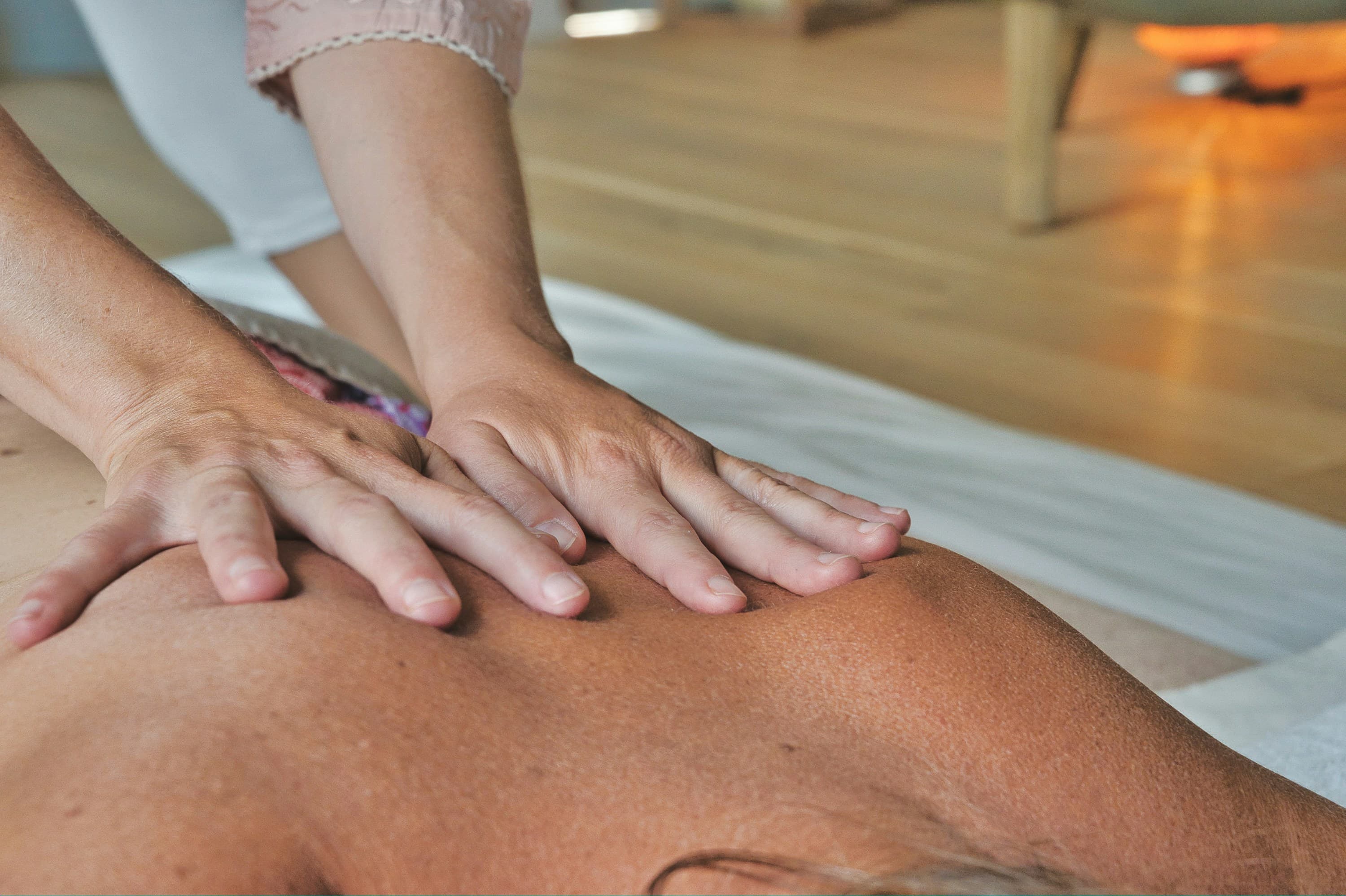 two hands massaging a back of a person