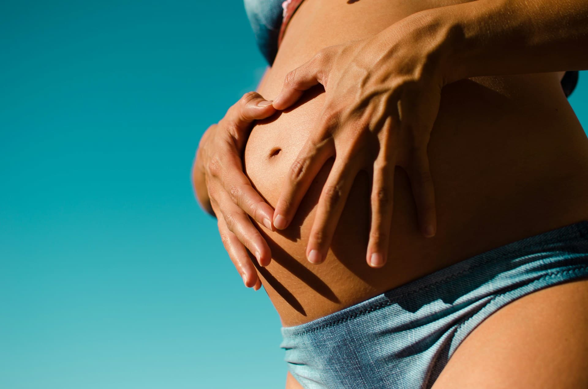 Pregnant woman receiving a gentle prenatal massage to relieve back pain, reduce swelling, and promote maternal relaxation and wellness