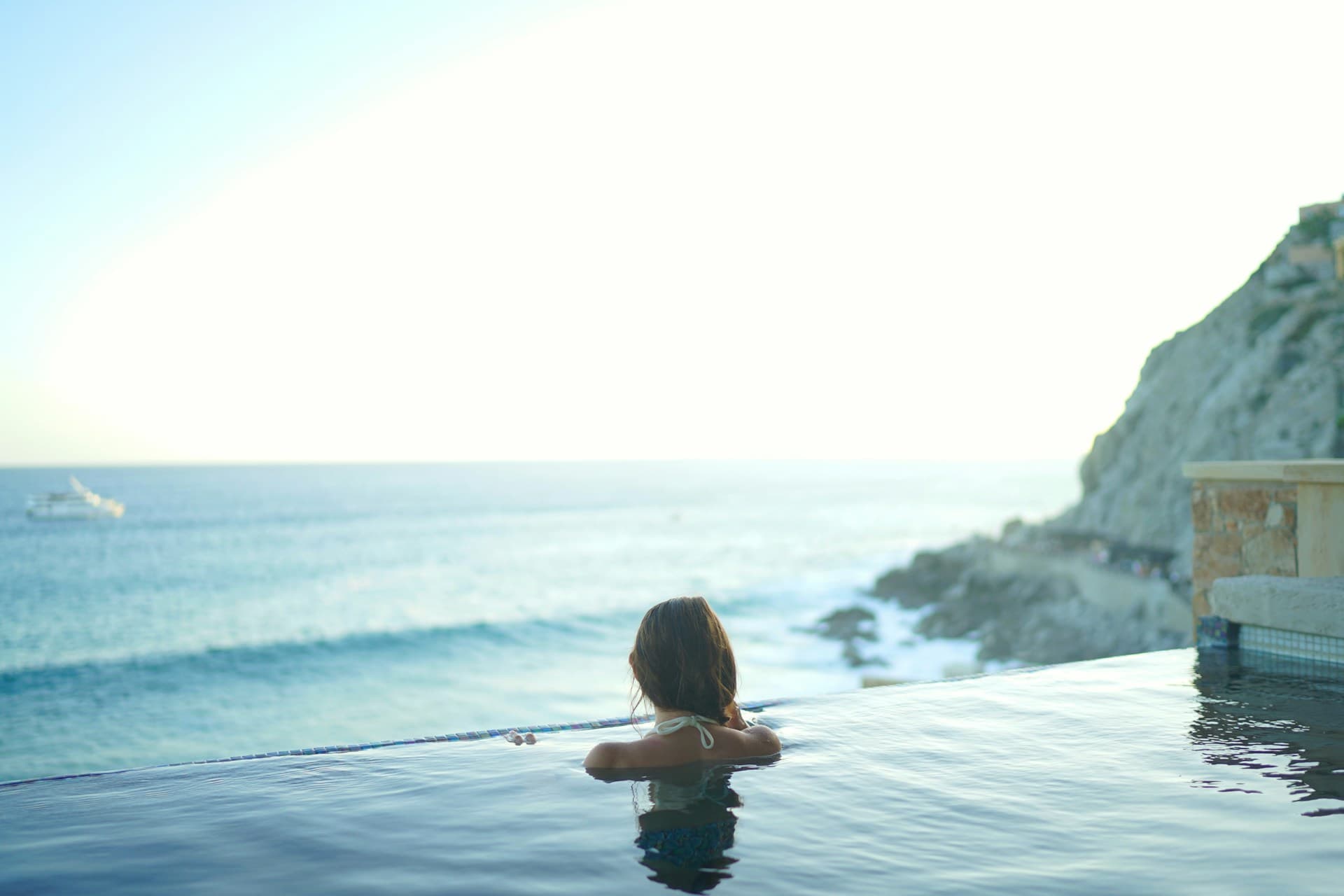 Woman relaxing in an infinity hydrotherapy pool at a coastal spa, exemplifying a hydrotherapy option for couples massage treatments